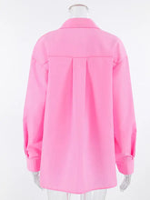 A vibrant pink oversized shirt with long sleeves, lace-up front, relaxed fit, and pleated back panel