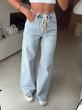 Lace-up high-waisted wide leg jeans in light-wash denim with a cream-colored drawstring waist detail
