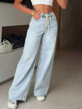 Light-wash denim lace-up high-waisted wide leg jeans with a white drawstring waist for a stylish fit