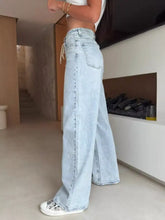 Light-wash denim lace-up high-waisted wide leg jeans with a drawstring waistband for a stylish wide leg fit