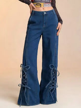 Blue denim wide leg jeans with lace-up detailing on lower legs for a stylish flare look