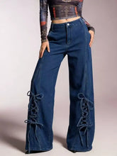 Wide leg jeans in deep blue denim featuring lace-up detailing with matching fabric ties along the outer sides