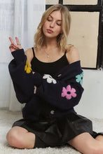 Black lantern sleeve cardigan with colorful floral appliques and delicate flower buttons