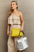 Woman in beige top holding yellow crossbody bag and large shoulder bag with colorful geometric pattern