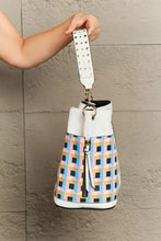 Large shoulder bag with multicolored plaid, white accents, and adjustable crossbody strap