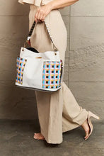 Large white faux leather shoulder bag with colorful geometric pattern and studded strap