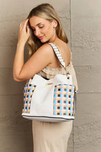 Large white faux leather shoulder bag with colorful geometric pattern and studded strap