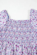 Purple floral smocked top with elasticized square neckline and short sleeves