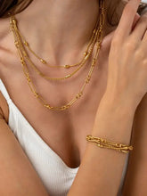 Model wearing layered chain necklace and matching 18k gold-plated chain bracelet