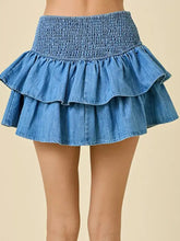 Denim skirt with a smocked waist and layered ruffle design in a two-tiered style for a stylish feminine look