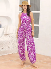 Vibrant purple and white leaf print sleeveless jumpsuit with halter neck