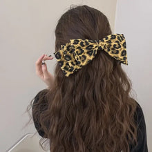 Leopard bow hair clip with long wavy brown hair