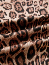 A soft flowing fabric leopard bow tie puff sleeve blouse with bold brown and black leopard print pattern