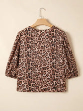 A soft mauve leopard bow tie puff sleeve blouse with bold print and puffed three-quarter sleeves