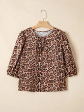 A mauve leopard bow tie puff sleeve blouse with soft fabric and subtle tie detail at the neckline