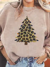 Beige corduroy sweatshirt with oversized fit featuring a leopard christmas tree graphic and care instructions label visible