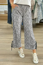 Leopard high waist pants with lace-up details and silver sneakers