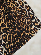 A close-up of leopard lip graphic top and shorts lounge set with bold black and tan spots on satin fabric showing sleeve length