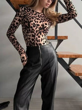 Black faux leather high-waisted trousers with front zipper paired with leopard long sleeve bodysuit shown from front