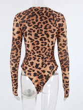 A form-fitting tan and black leopard long sleeve bodysuit with a stylish leopard long sleeve pattern