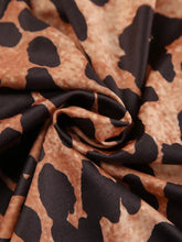 A soft flowing scarf with a bold brown and black leopard long sleeve print complements the leopard long sleeve bodysuit