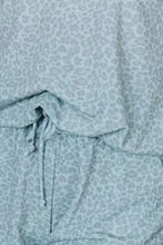 Light blue leopard-print drawstring shorts with adjustable waistband paired with notched top sleeve length detail visible