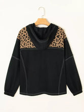 Black quarter zip hoodie with leopard print shoulder panels, white contrast stitching, and slightly stretchy fabric