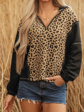 A cozy leopard-print quarter zip hoodie with black sleeves, contrasting stitching, and slightly stretchy soft fabric