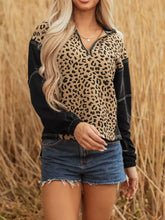 Leopard patchwork quarter zip hoodie with black long sleeves, zipper neckline, knotted cuff, and slightly stretchy fabric