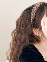 Woman in leopard polyester wide headband with wavy brown hair and pearl earring