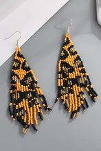 Orange and black beaded dangle earrings with leopard print fringe design