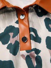 Orange faux leather button placket with silver buttons on short sleeve blouse featuring green and pink leopard print