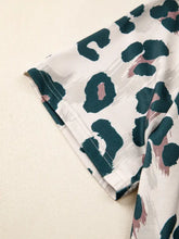 Leopard print short sleeve blouse with white base and bold dark teal and dusty rose brushstroke pattern