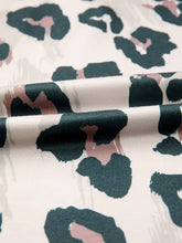 A short sleeve blouse with a modern leopard print in black and dusty rose on soft off-white flowy fabric