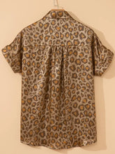 Short-sleeved leopard print button-down shirt in metallic gold and brown hanging on wooden hanger