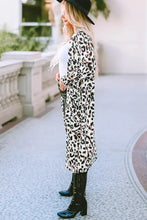 Leopard print duster coat with black buttons and wide-brimmed hat