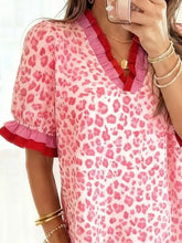 A pink leopard print blouse with ruffled red trim on the neckline and sleeves leopard print frill short sleeve blouse