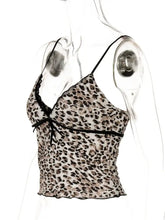 A delicate leopard print camisole with black lace trim and a matching bow at the front
