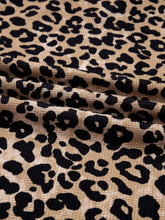 Leopard print long sleeve hoodie with pocket in tan corduroy fabric featuring a bold black pattern and slightly stretchy material