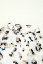 Leopard print ruffled blouse with bell sleeves, blue accents, and silver buttons