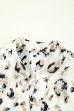 Leopard print ruffled blouse with bell sleeves, floral accents, silky fabric