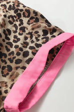 Leopard print short sleeve shirt featuring leopard print fabric with a vibrant pink satin cuff detail