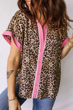 Leopard print short sleeve shirt featuring leopard print fabric with pink trim and buttons for stylish wear