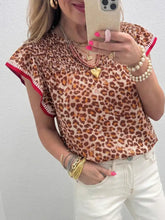 Leopard print smocked notched blouse featuring a leopard print top with ruffled short sleeves and red trim