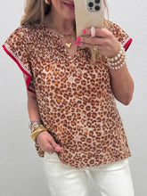 Leopard print smocked notched blouse with short flutter sleeves red-trimmed cuffs v-neckline and soft fabric