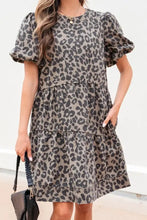 A women’s denim dress with a gray and black leopard print, round neck puff sleeves, and a relaxed tiered fit