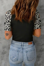 Woman in leopard round neck short sleeve top with distressed jeans