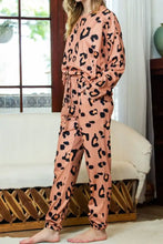 Peach-colored leopard print lounge set with long sleeve round neck top and drawstring pants featuring adjustable waist