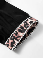 Black puff sleeve blouse with leopard trim puff cuff accented by white and black striped trim for stylish wear