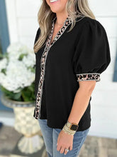 Black puff sleeve blouse with leopard trim puff accents and voluminous sleeves for stylish wear